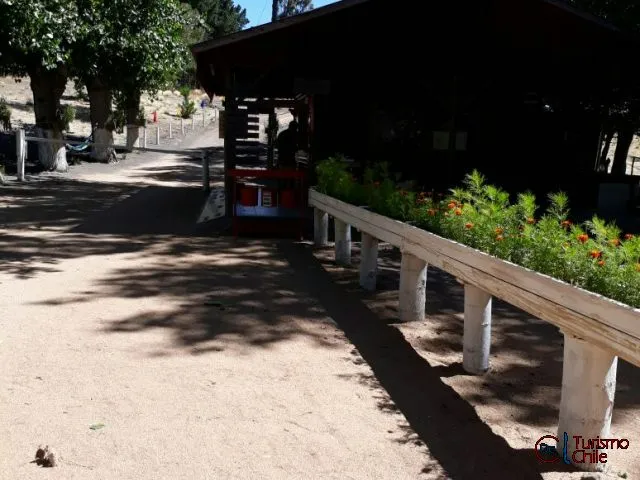 Entrada del camping con quincho y flores en Camping y Cabañas Porvenir