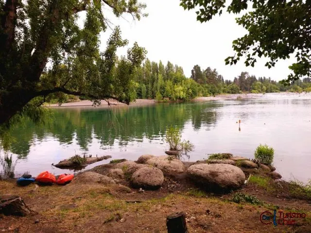 Río Laja con kayaks, rocas y árboles en la orilla de Camping Porvenir